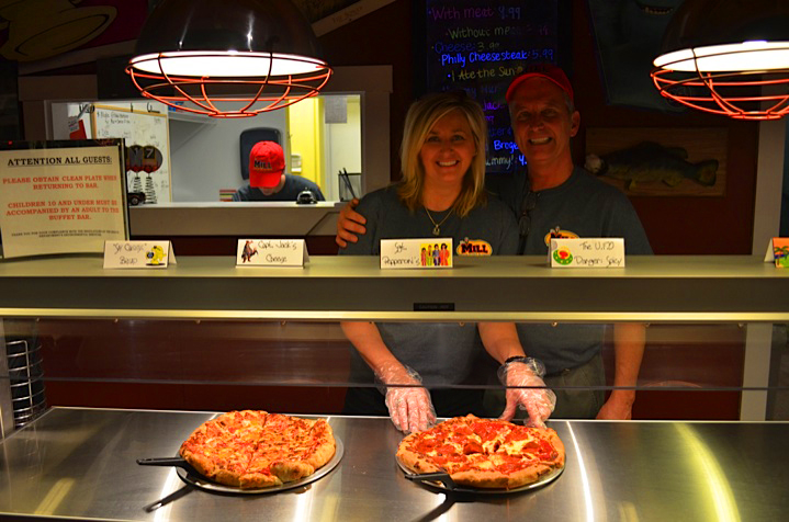 Staff presenting fresh pizzas
